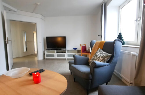 Maison Fasson Ferienwohnung 1 Wohnzimmer Sessel und Fernseher