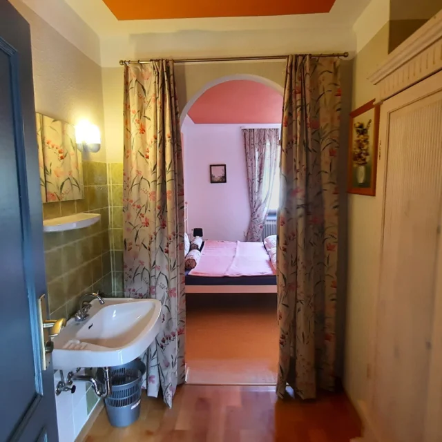 Ein erster Schritt durch die Tür… und der Alltag bleibt leise draußen 🍂🧡

Im Vordergrund der Waschbereich – schlicht, ruhig, fast wie ein sanfter Übergang.
Und dann dieser Blick durch den Rundbogen… der Vorhang bewegt sich leicht… und gibt den Raum dahinter nur ein Stück weit frei.

Ein kleiner Moment der Neugier.
Ein Hauch von Romantik.
Ein Zimmer, das sich nicht sofort ganz zeigt – sondern entdeckt werden möchte ✨

Genau darin liegt sein Zauber:
Schicht für Schicht ankommen.
Langsam eintauchen.
Und spüren, wie Ruhe einkehrt.

Das Herbstzeitlosen-Zimmer im Maison Fasson ist Teil unseres liebevoll gestalteten Gruppenhauses im Vintage-Stil – ein Ort für gemeinsame Auszeiten und stille Lieblingsmomente 🏡💜
Und es kann bereits gebucht werden.

Mehr Infos unter www.maison-fasson.de 🌿

#MaisonFasson #MaisonFassonMomente #ZuhauseAufZeit #HausMitSeele #VintageCharme #FerienhausNordpfalz #Romantik #HerbstGefühle #DetailsDieVerzaubern